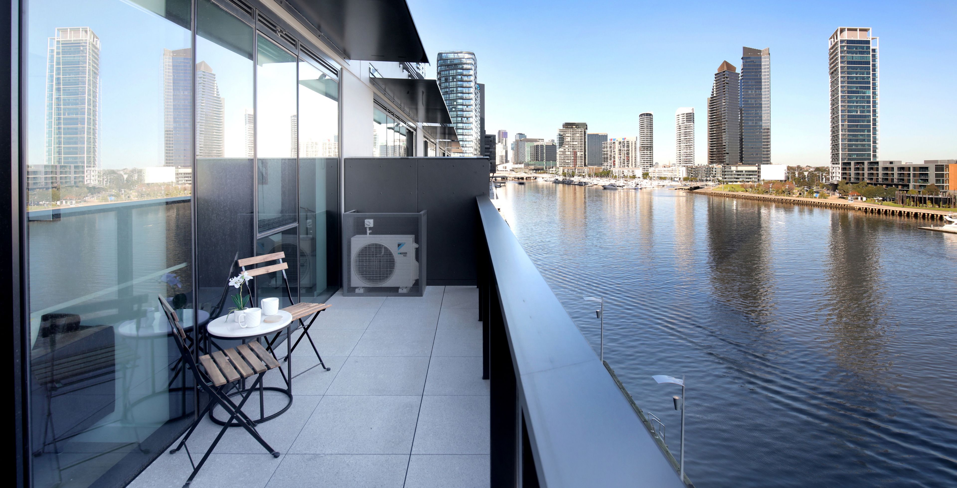 Un balcon offrant une vue sur les toits d’une ville et sur une rivière.