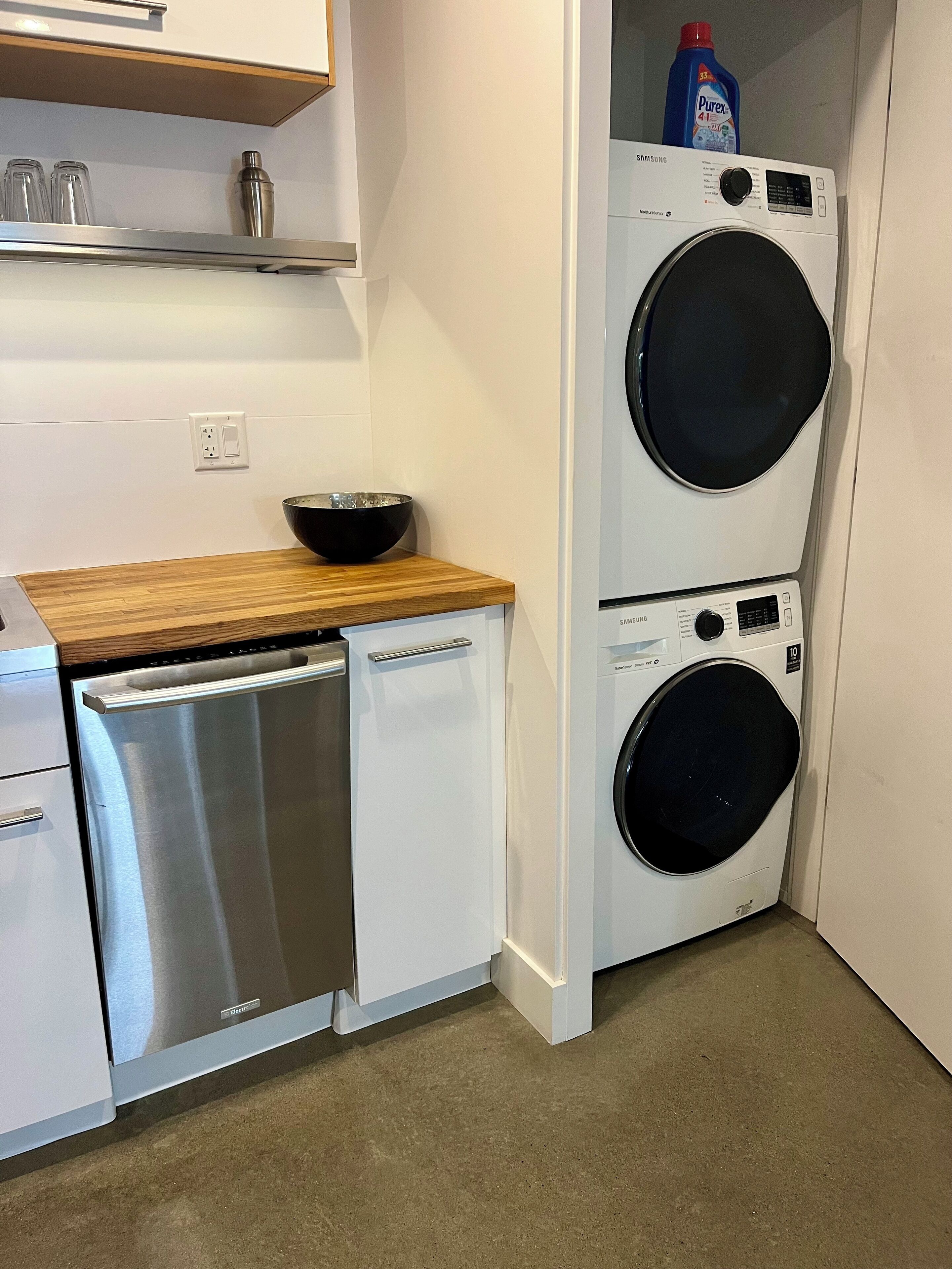A compact kitchen with a dishwasher, a sink, and a double washing machine.