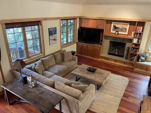 TV connectée, cheminée, table de tennis de table, livres