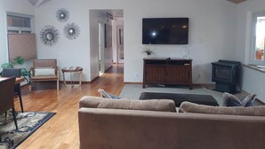 A living room with a sofa, TV, wooden cabinet, and a fireplace.