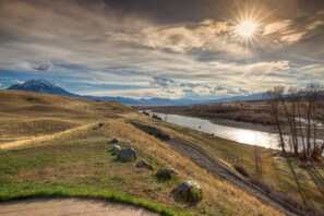 A river flowing through a valley with mountains in the background and a clear sky. - Riverfront property with the best views in Paradise valley! (Livingston)