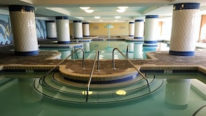 Une piscine intérieure dotée d’une plateforme circulaire centrale et d’escaliers disposés tout autour.