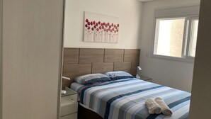 A bedroom with a bed, a nightstand, a wall-mounted artwork, and a window. - Newly designed apartment - leisure area with infinity pool and incredible views.  (Ingleses Norte)
