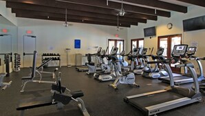 A gym with multiple treadmills, stationary bikes, and weight machines.