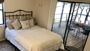 Une chambre avec un lit, une fenêtre et une vue sur une terrasse extérieure.