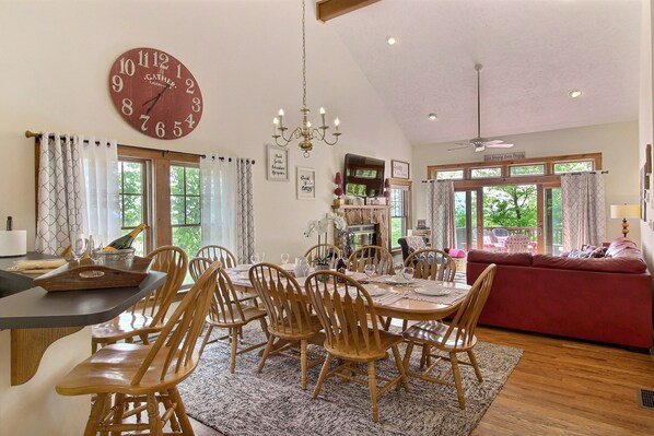 A dining area with wooden chairs, a round table, and a large wall clock. - Mountain View Chateau • Deck w/ Camelback Views • Welcome Gift • 200+ 5  Reviews (Tannersville)