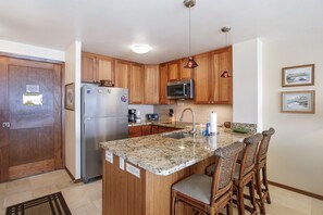 Enjoy cooking in this well-equipped kitchen with a central island, stainless steel appliances, and a granite countertop.