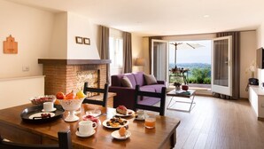 A dining area with a table set for breakfast, a fireplace, and a view of the outdoors. - Raffaello Apartment with garden (San Gersolé-torre Rosse)