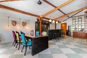 Une cuisine moderne dotée d’un îlot central, de poutres en bois et d’un carrelage à motifs géométriques.