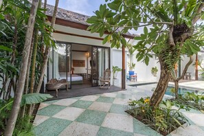 Une villa moderne avec un sol à carreaux, une piscine et une végétation tropicale luxuriante.