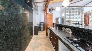 Een moderne keuken met een marmeren aanrecht, houten balken en een zwart-wit betegelde vloer.