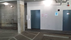 A parking garage with two doors, a reserved parking sign, and a tow warning sign. - MBV 4Br - Ocean Breeze (Myrtle Beach)