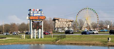 A sign for a family race park with a Ferris wheel in the background.