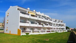 A multi-story hotel with balconies, a flat roof, and a well-maintained lawn. -   Modern 1 bedroom apartment on the sea front of Cabanas De Tavira   (Cabanas de Tavira)