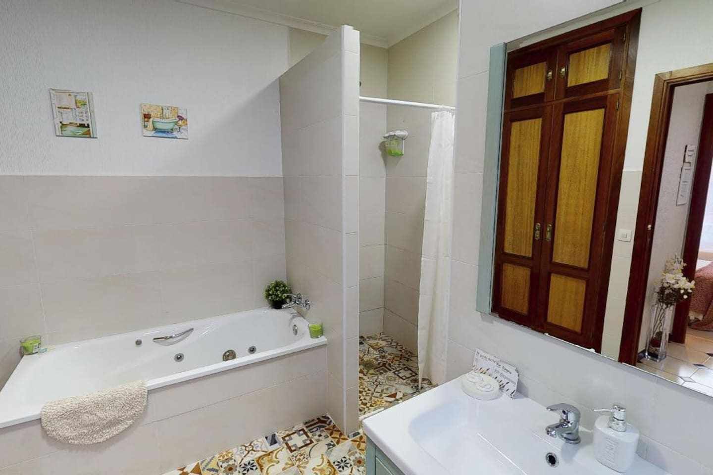 Une salle de bain avec une baignoire, une douche, un lavabo et un miroir.