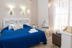 A hotel room with a bed, a nightstand, a chair, and a table with a hat and teapot. - Apartment in La Baule with Sea View (PORNICHET)