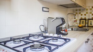 A kitchen with a gas stove, a sink, and a toaster. - S'Omu e Mari by All4sardinia  (Cardedu)