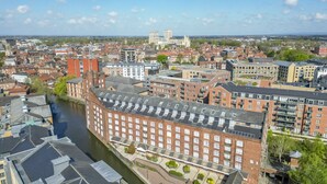 A high-rise building with a river in the foreground, surrounded by other buildings and a distant cathedral. - Cocoa Suites 45 - York city centre studio (sleeps 2) (York)