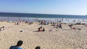 A beach with people sunbathing and swimming, and a clear sky. - Sea Breeze Stay w/ Pool (PORNICHET)