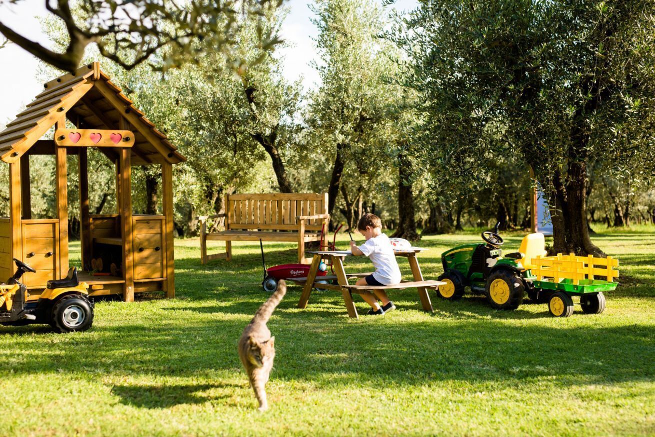 Una casita de madera con un banco y un tractor de juguete.