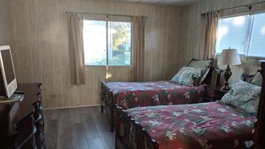 A bedroom with two wooden beds, a dresser, a lamp, and a window with curtains. - A few short Miles from siesta key (Sarasota)