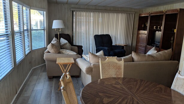 A living room with a sofa, armchair, and a round wooden table. - A few short Miles from siesta key (Sarasota)