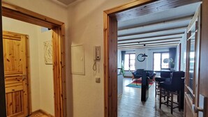 A wooden interior with a wooden door, a wall-mounted phone, and a clock. - Villa pond view with balcony and view to the Frankenteich - Gohr apartments (Stralsund)
