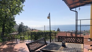 An outdoor patio with metal furniture, a view of the sea, and a clear sky. - ESPERIA, splendid sea view and immersed in the typical greenery of the Trieste Karst (Trieste)