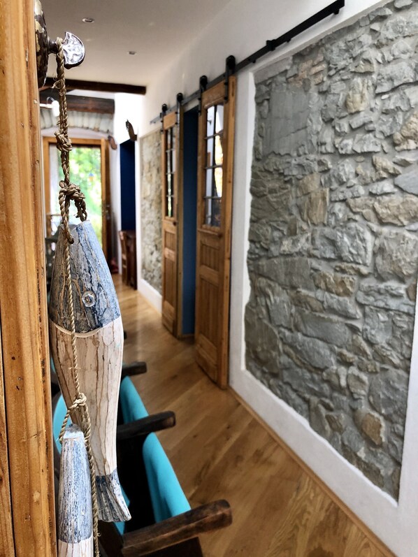 A hallway with wooden flooring, stone walls, and a rustic door. - ESPERIA, splendid sea view and immersed in the typical greenery of the Trieste Karst (Trieste)
