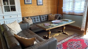 A cozy living room with a sectional sofa, a coffee table, and a patterned rug.