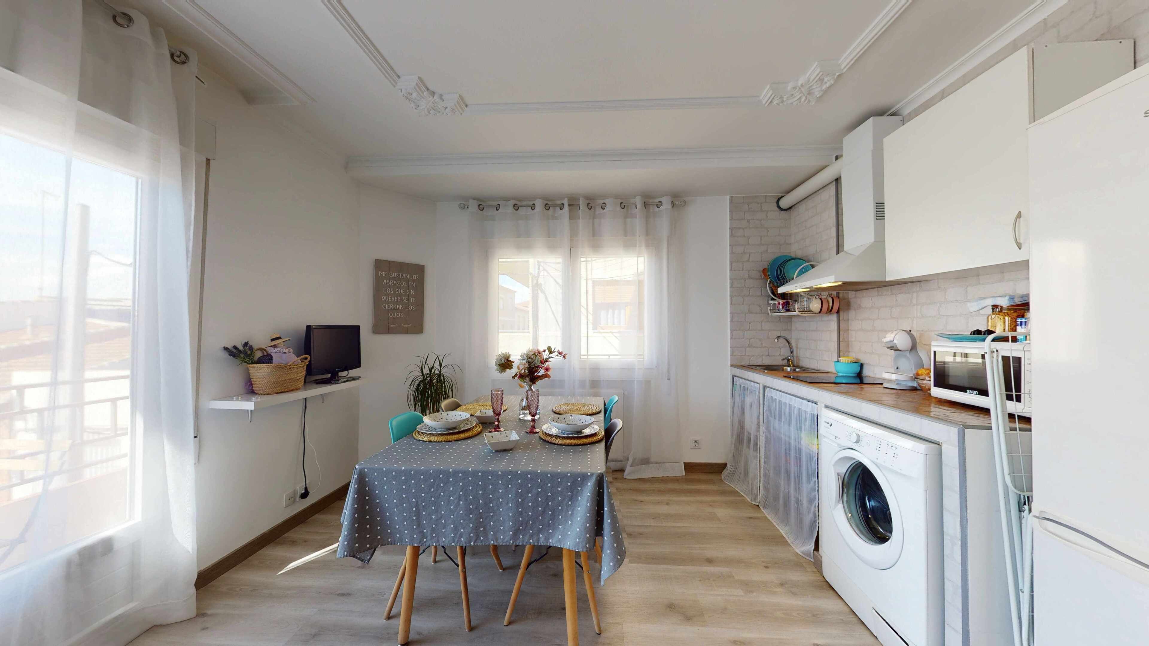 Une cuisine compacte équipée d’un lave-linge, d’un four à micro-ondes et d’un évier.
