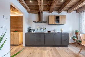 Uma cozinha moderna com vigas de madeira, uma ilha central e armários embutidos.
