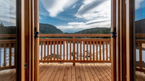 A wooden deck with a view of a lake and mountains.