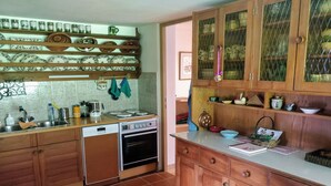 Eine Küche mit Holzausstattung, einem Einbauofen und einer Arbeitsplatte mit verschiedenen Küchenutensilien.