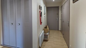 A hallway with a radiator, a basket, and a door with a lock. - Central Arcachon - Cozy T2 for 4 with Balcony, Parking, and Bike Storage (Arcachon)