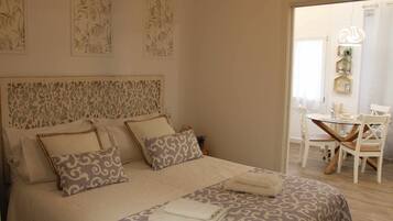 A neatly arranged bedroom with a large bed, a bedside table, and a chair.