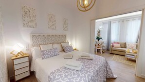 Ein Schlafzimmer mit einem Bett, Nachttischen, einem Schreibtisch und einem Sofa.