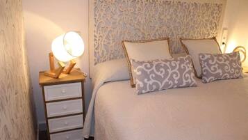 Een slaapkamer met een bed, twee bedlampen en een nachtkastje met lades.