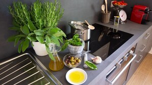 A modern kitchen with a built-in oven, a coffee machine, and various cooking utensils. - Brunelleschi Apartment (Impruneta)
