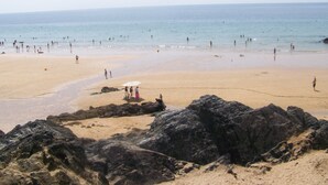 A beach with rocky outcrops in the foreground and people in the water. - Detached house, facing south, av garage and enclosed garden, 350 m from the beach (Finistere (Clohars-Carnoët)