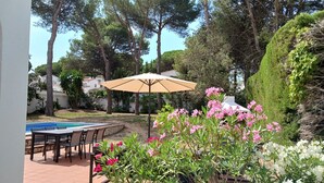 A patio with a pool, outdoor seating, and a large umbrella.