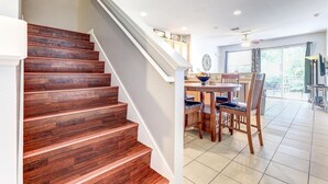 A staircase with wooden steps leading to a dining area with a table and chairs.