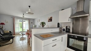 Eine moderne Küche mit weißen Schränken, einem Einbauofen und einer Kaffeemaschine.