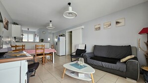 Ein kompakter Wohnraum mit Küchenzeile, Essbereich, Sofa und Couchtisch.