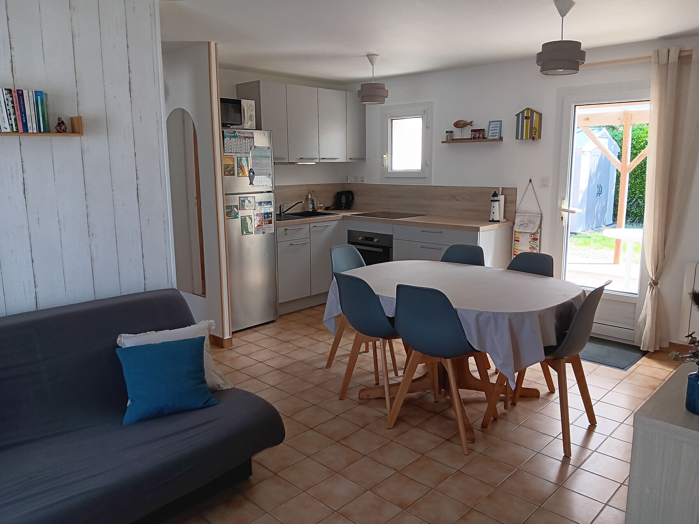 A modern kitchen with white cabinets, a dining table with chairs, and a built-in oven.