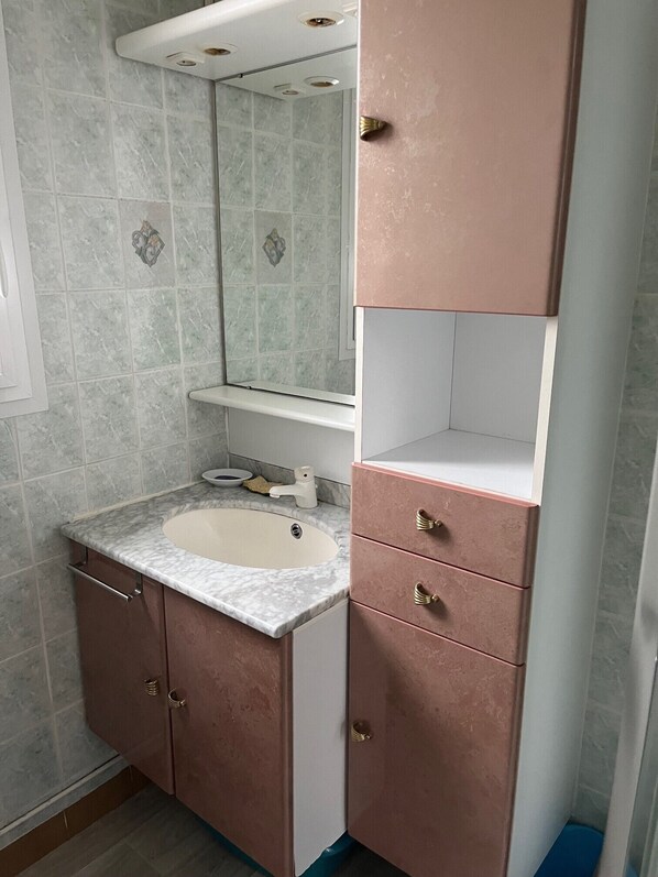 A bathroom with a sink, mirror, and pink cabinets. - Bénodet, apartment 60m2 in dupleix, 100m from La Plage, comfortable (Bénodet)