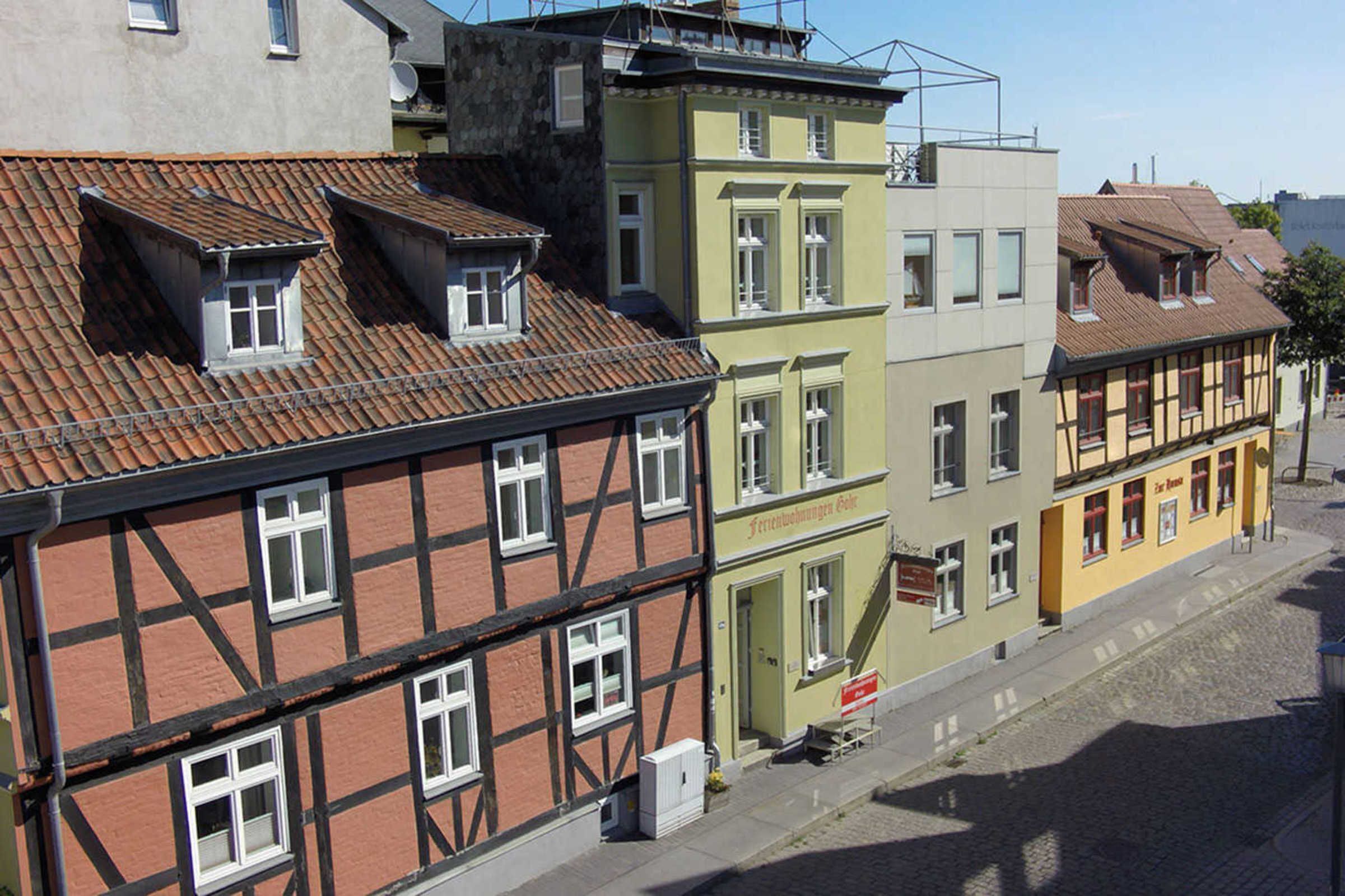 A row of traditional European buildings with distinct architectural styles, including half-timbered and painted facades.