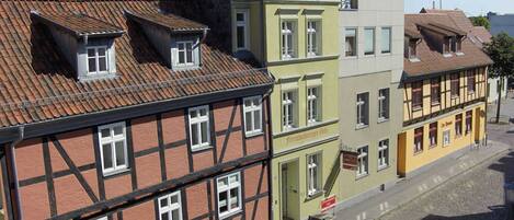 A row of traditional European buildings with distinct architectural styles, including half-timbered and painted facades.