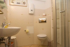 A bathroom with a sink, toilet, and a towel rack.