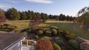 A well-maintained golf course with neatly trimmed hedges and trees, a clear sky, and a view of the property from a balcony. - Perfect For Large Family Get Aways Or Your Gorgeous Ranch Style Wedding. (Arroyo Grande)